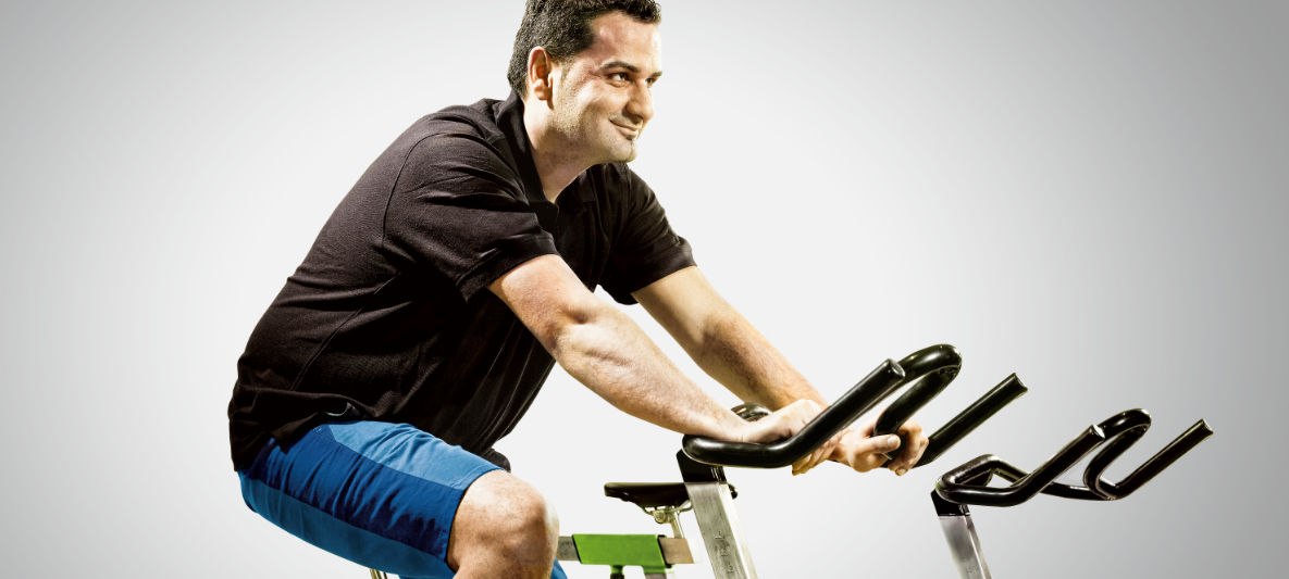 Mann fährt Rad auf dem Ergometer Ein Mann faehrt Rad auf dem Ergometer